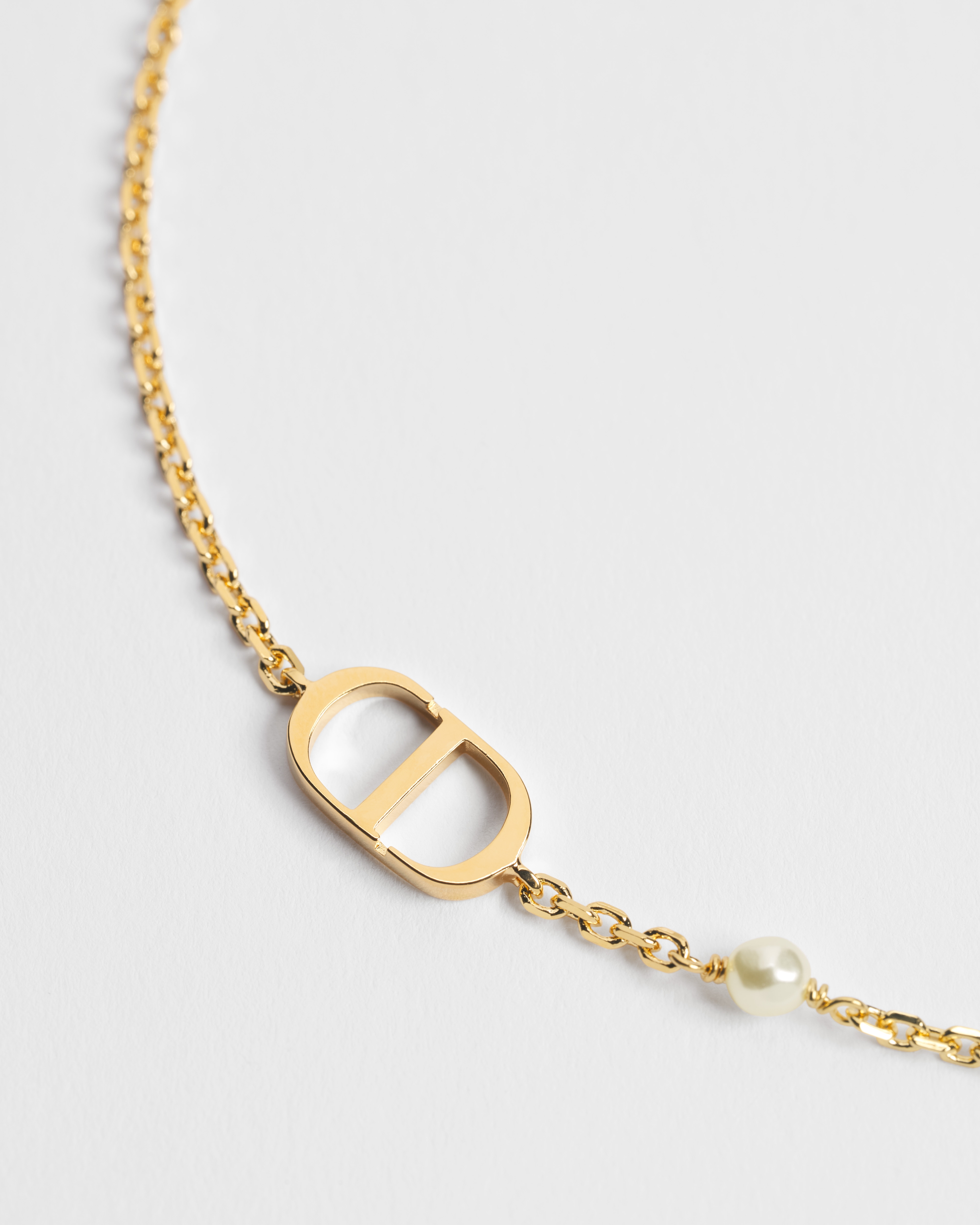 Pulseira Petit CD Metal com acabamento dourado e pérola de resina branca E09