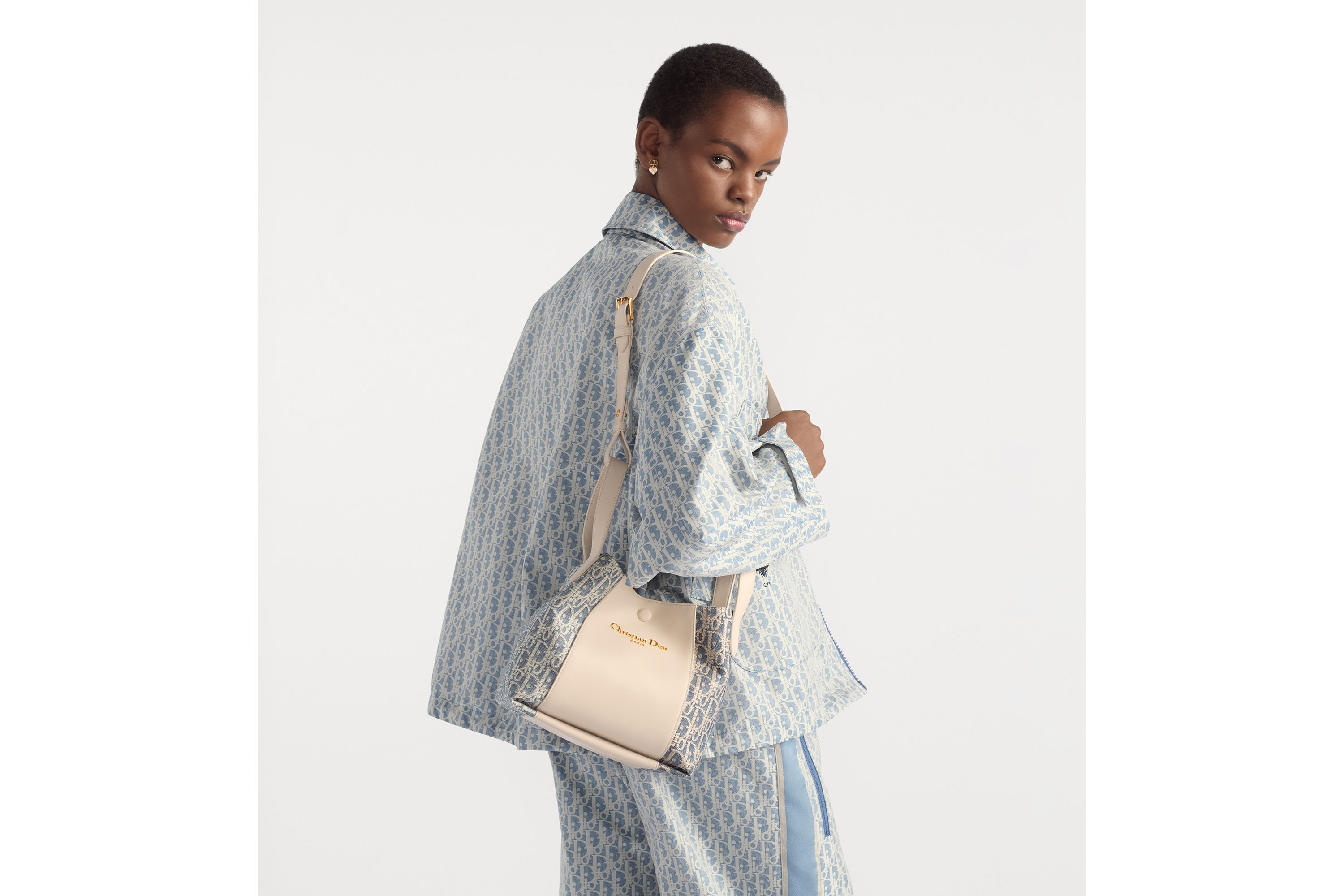 Look Sac seau Signature Small Tissu Chambray avec effet raphia Dior Oblique bleu et cuir de veau lisse couleur biscuit clair E06
