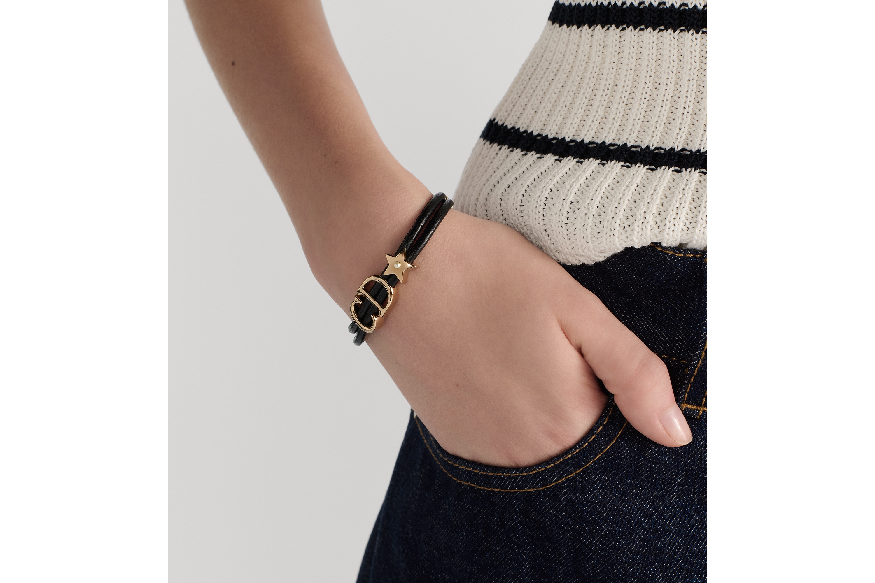 سوار Dior Saddle من الجلد معدن ذهبي وجلد الخروف باللون الأسود ولؤلؤة من الراتنج الأبيض E11